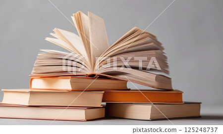 Open book and stack of hardcover books on the table. Concept back to school, education, library. Open book and stack of hardcover books on the table. Concept back to school, education, library. 125248737