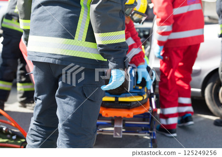 Firefighters and paramedics in a rescue operation after road traffic accident 125249256