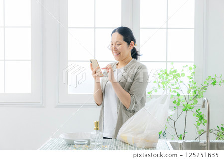 看智慧型手機的女人,家庭主婦 看智慧型手機的女人,家庭主婦 125251635