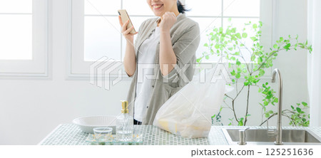 看智慧型手機的女人,家庭主婦 看智慧型手機的女人,家庭主婦 125251636