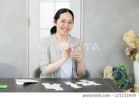 Smiling woman holding a smartphone, household accounting app 125251659