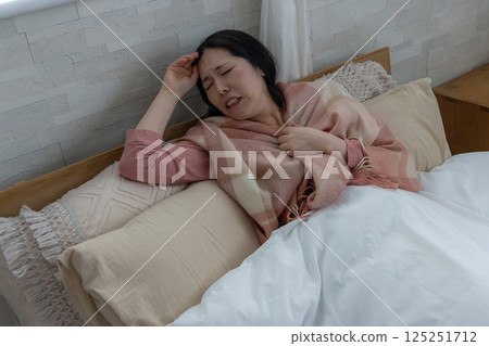 一名婦女因健康狀況不佳而抱頭 125251712