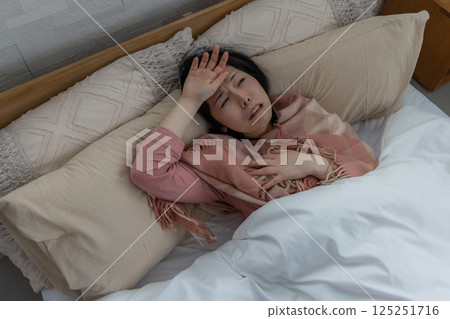 一名婦女因健康狀況不佳而抱頭 125251716