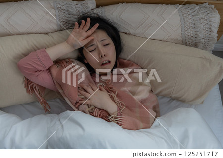 一名婦女因健康狀況不佳而抱頭 125251717