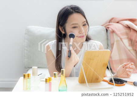 Middle-aged woman putting on makeup 125251952