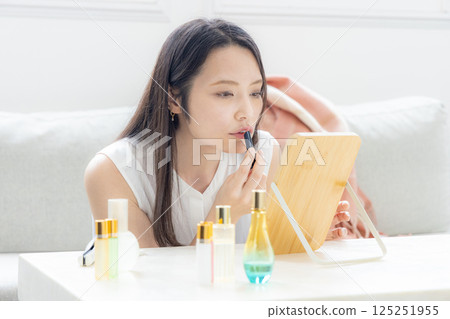 Middle-aged woman putting on makeup 125251955