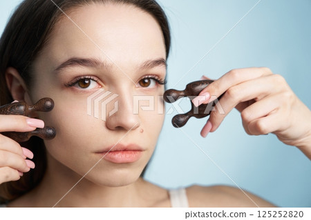 Facial massage technique using wooden tools for relaxation and beauty care Facial massage technique using wooden tools for relaxation and beauty care 125252820