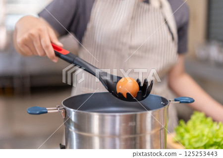 Smiling Chef Cooking with Fresh Ingredients in a Professional Kitchen 125253443