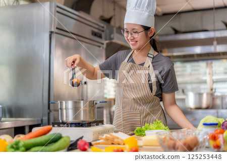 Smiling Chef Cooking with Fresh Ingredients in a Professional Kitchen Smiling Chef Cooking with Fresh Ingredients in a Professional Kitchen 125253448
