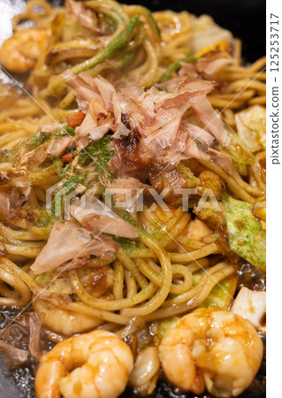 Delicious fried noodles with shrimp sauce served on a hot plate 125253717