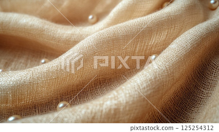 Luxury White Pearls Lying on Coarse Woven Beige Linen Background Close-Up 125254312