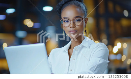 Professional woman working on laptop in modern office 125255008