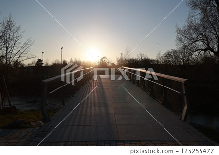 A bridge with a sun shining on it 125255477