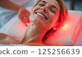 Female enjoying rejuvenating light therapy session with radiant smile 125256639