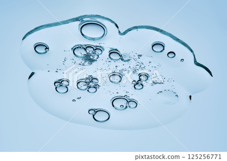 A beautiful swatch of hyaluronic serum with bubbles on a blue background. View from below. A beautiful swatch of hyaluronic serum with bubbles on a blue background. View from below. 125256771