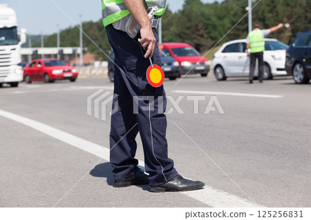 Police officer controlling traffic on the highway 125256831