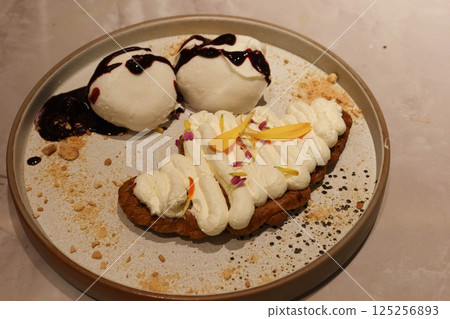 close up of dessert plate, including vanilla ice cream drizzled with a berry sauce, mochi and Croffle topped with whipped cream close up of dessert plate, including vanilla ice cream drizzled with a berry sauce, mochi and Croffle topped with whipped cream 125256893