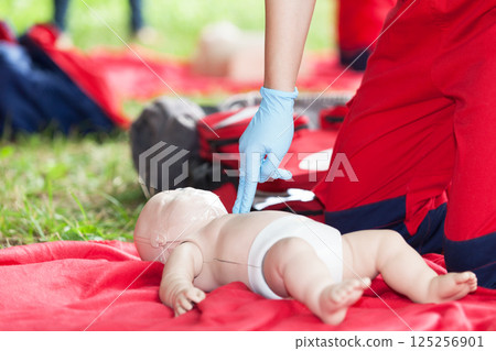 Baby CPR dummy first aid training. Heart massage. 125256901