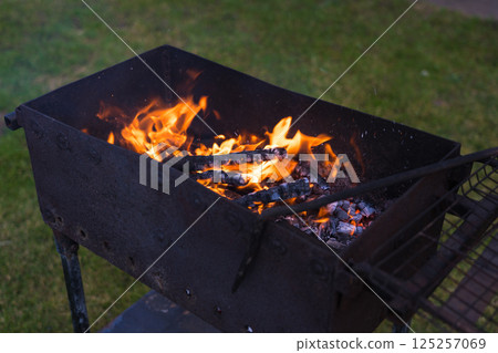 Smoldering coals in the grill. Coals in the grill. Evening in the village Smoldering coals in the grill. Coals in the grill. Evening in the village 125257069