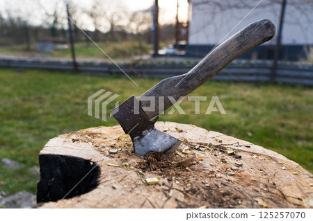 The axe is hammered into an oak block. The axe is stuck in the deck 125257070