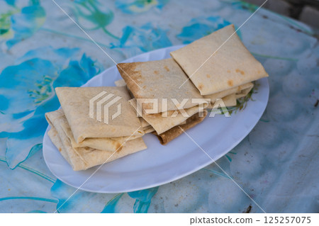 Cheese wrapped in pita bread. Lavash on a platter. Lavash culinary dish Cheese wrapped in pita bread. Lavash on a platter. Lavash culinary dish 125257075