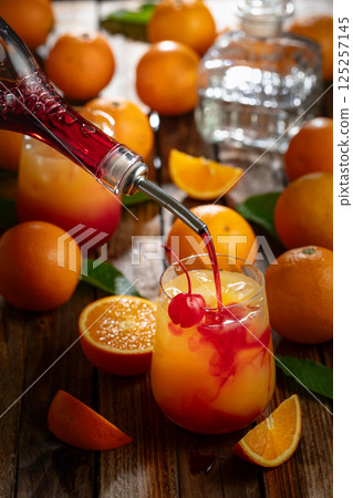 Classic tequila sunrise cocktail on an old wooden table. Classic tequila sunrise cocktail on an old wooden table. 125257145
