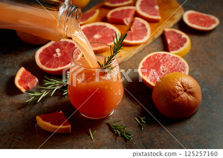 Grapefruit juice is poured into a glass. 125257160