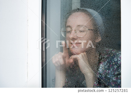 Young girl at the old window 125257281
