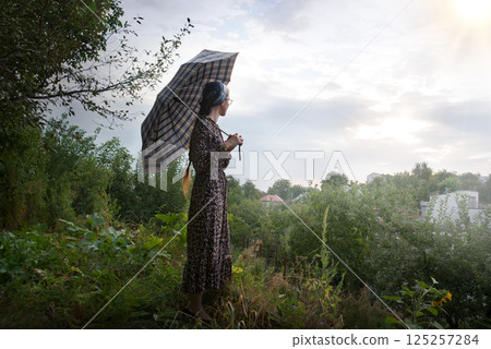 Young girl with big umbrella 125257284
