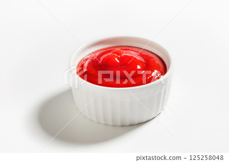 Ketchup in a white bowl isolated on white background. Portion of tomato sauce with clipping path 125258048