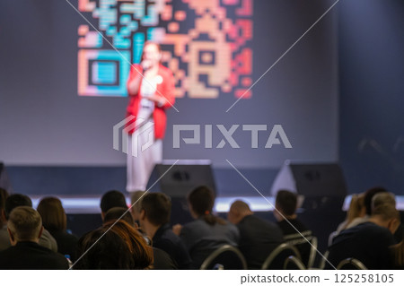 Speaker presenting at business conference in modern stage setting 125258105
