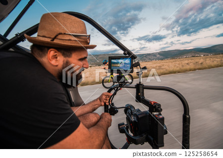 A videographer recording a triathlete riding his bike preparing for an upcoming marathon.Athlete's physical endurance and the dedication required to succeed in the sport. 125258654