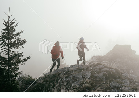 Trail running couple man and woman running on a mountain path Trail running couple man and woman running on a mountain path 125258661