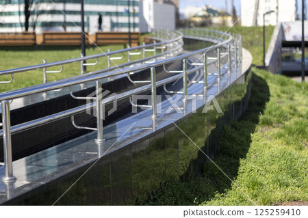 Long row of polished stainless steel railings, ramp for going up or down 125259410