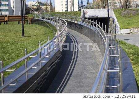 Long row of polished stainless steel railings, ramp for going up or down 125259411