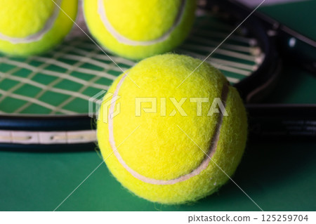 Very close-up of tennis ball and raket on blurred background. 125259704