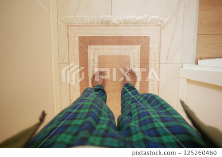 Standing on a decorative mat in comfortable pajamas at home 125260460