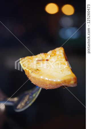 Delicious slice of dessert served on a fork at an evening gathering Delicious slice of dessert served on a fork at an evening gathering 125260473