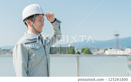 Workers wearing work clothes standing in the blue sky (construction, architecture, design, real estate, civil engineering, construction, site supervision, transportation) 125261800