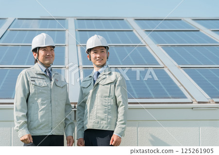 電力公司或電氣承包商穿著工作服的工程師站在太陽能發電/太陽能板（清潔能源）前 125261905