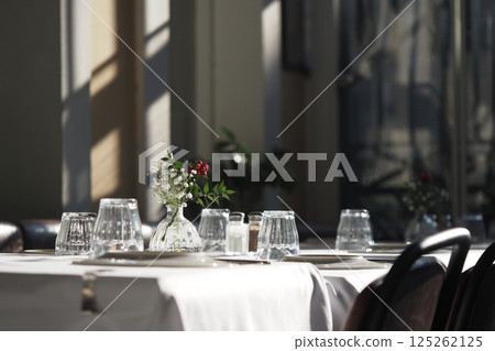 Elegant dining setup in bright restaurant during daylight hours Elegant dining setup in bright restaurant during daylight hours 125262125
