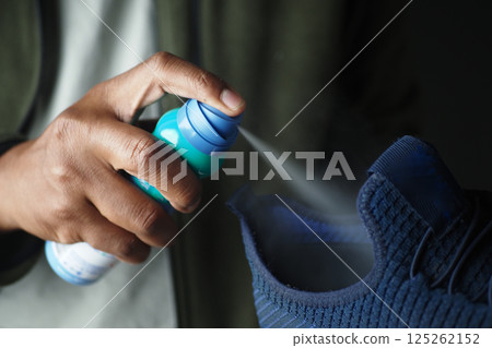 Applying shoe cleaner to a sneaker indoors 125262152