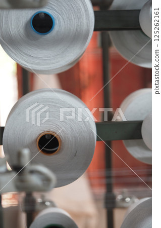 Spools of thread in a textile factory during daylight hours 125262161