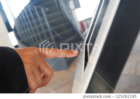 User interacting with digital touchscreen at a modern facility User interacting with digital touchscreen at a modern facility 125262195