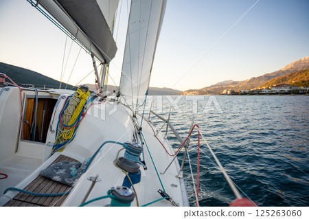 Yacht sailing in Adriatic sea. Close-up view of the deck, mast and sails. Yachting concept Yacht sailing in Adriatic sea. Close-up view of the deck, mast and sails. Yachting concept 125263060