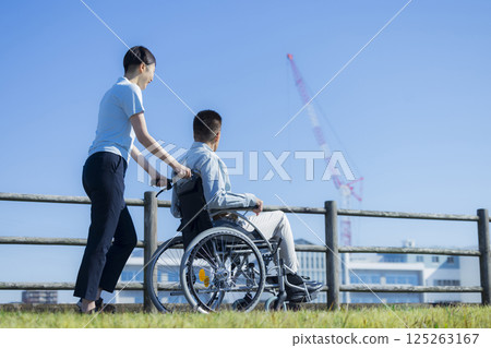 乘坐輪椅和照料者的資深男性 125263167