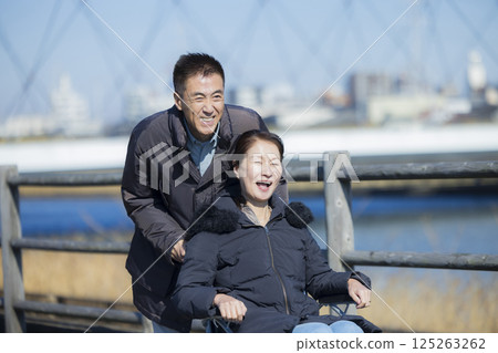 丈夫協助妻子坐輪椅 丈夫協助妻子坐輪椅 125263262