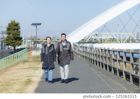 一對穿著外套散步的中年夫婦 一對穿著外套散步的中年夫婦 125263315