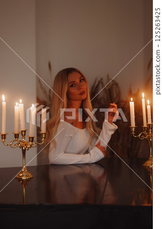 Elegant woman in white dress leaning on black piano. Loft interior. Elegant woman in white dress leaning on black piano. Loft interior. 125263425