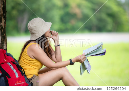 Women hiker oWomen hiker or traveler with backpack adventure holding map to find directions r traveler with backpack adventure holding map to find directions and siting relax Women hiker oWomen hiker or traveler with backpack adventure holding map to find directions r traveler with backpack adventure holding map to find directions and siting relax 125264204